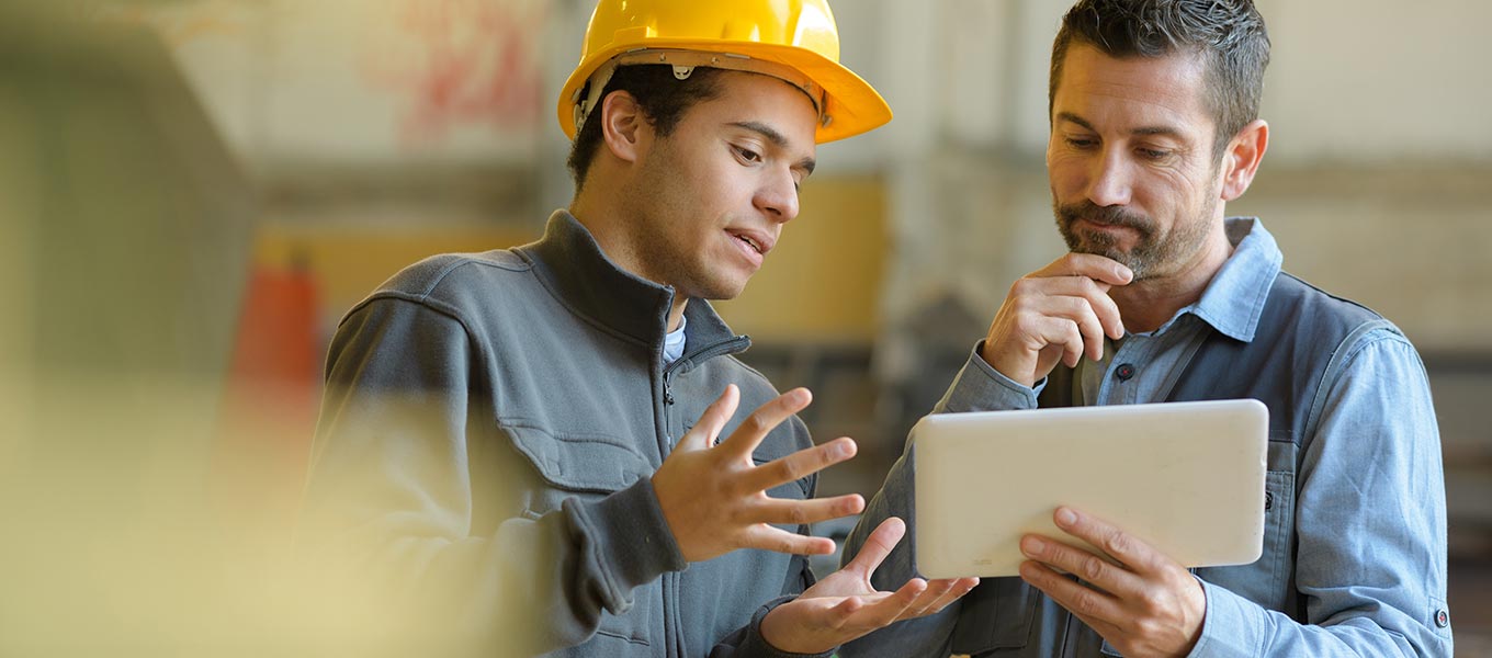 construction people reviewing plans on tablet