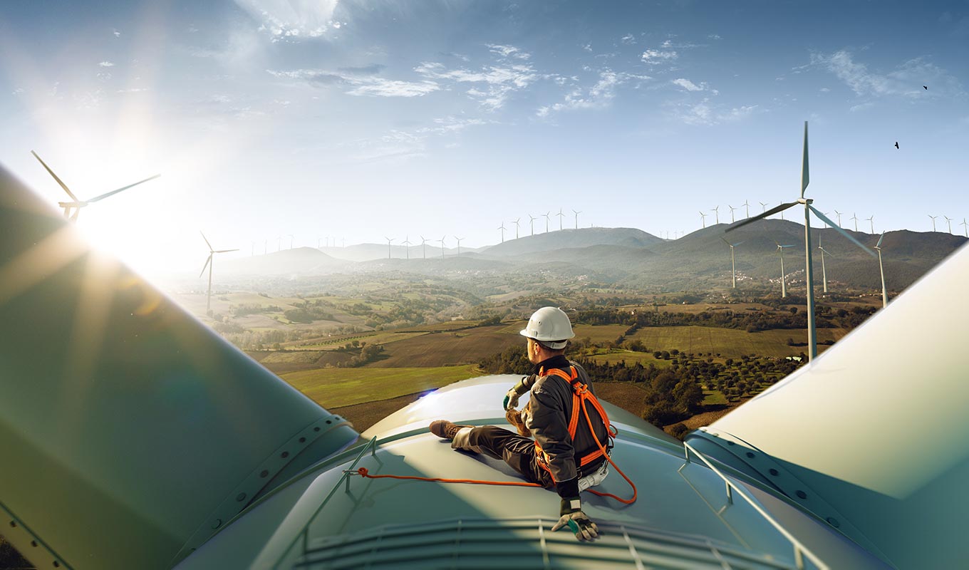 construction worker on top of wind turbine