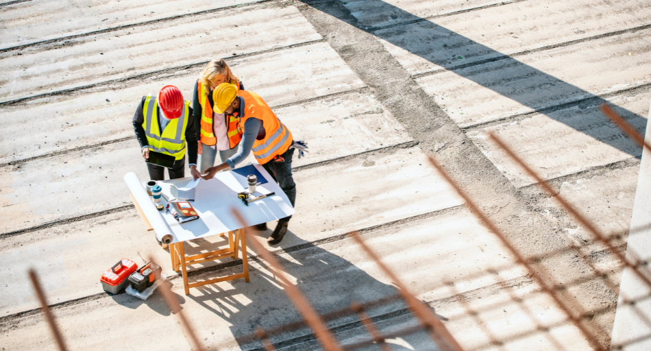 overhead shot of three construction workers looking at documents