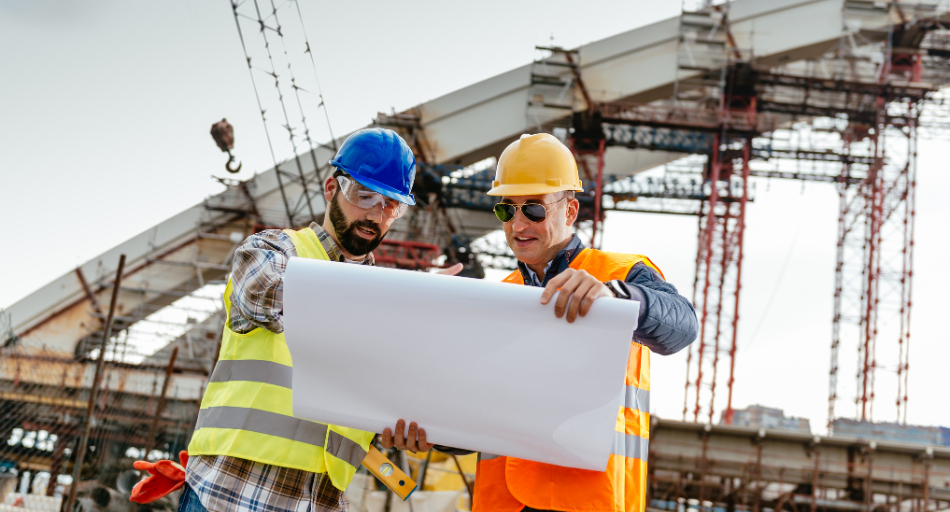 engineers in hardhats reviewing maps and documents